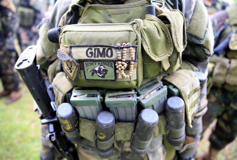 A rosary is seen hanging on a vest of a government soldier while praying before their assault. Philippines battles,Islamist rebels,Government troops,Marawi City,Maute group,southern Philippines