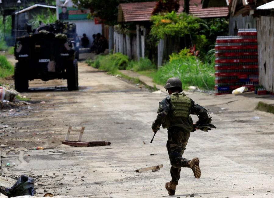 A government soldier runs towards his colleague. Philippines battles,Islamist rebels,Government troops,Marawi City,Maute group,southern Philippines