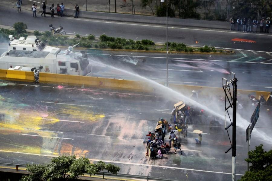 Opposition supporters clash with riot security forces in Caracas. Venezuela turns water cannons,Venezuela,Venezuela riot police,water cannons,anti-government protesters,protesters