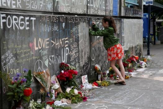 A girl leaves a message at a makeshift memorial for two men who were killed on a commuter train while trying to stop another man from harassing two young women who appeared to be Muslim, in Portland, Oregon, May 29, 2017.