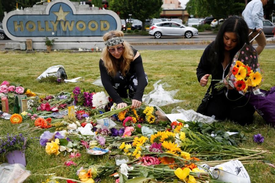 Portland residents Sedona Soulfire, 41, left, and Kat Ablola, 38, arrange flowers at a makeshift memorial at the Hollywood Transit Station in Portland. Oregon,Portland train stabbing victims,Portland train stabbing,Memorial for Portland train stabbing victims,Portland