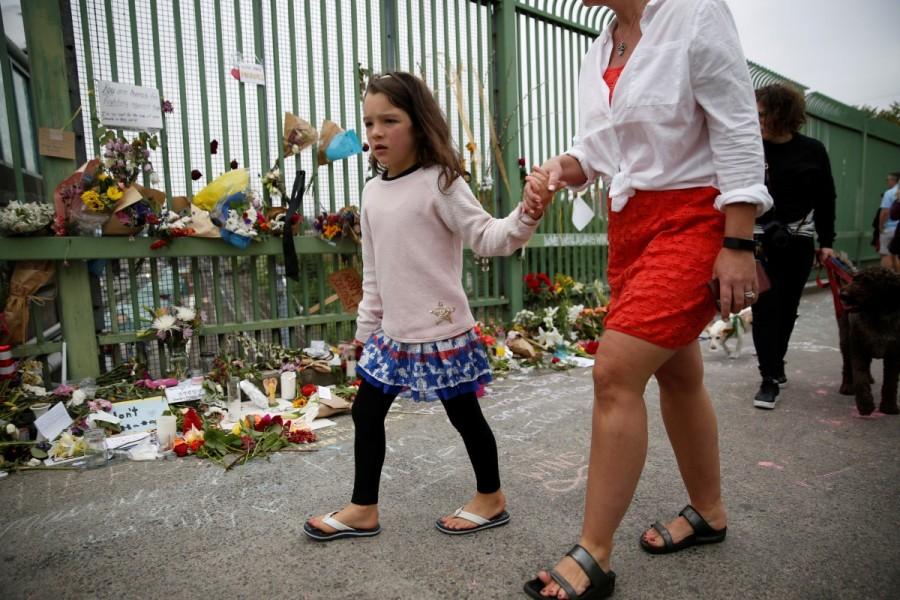 People walk past a makeshift memorial. Oregon,Portland train stabbing victims,Portland train stabbing,Memorial for Portland train stabbing victims,Portland