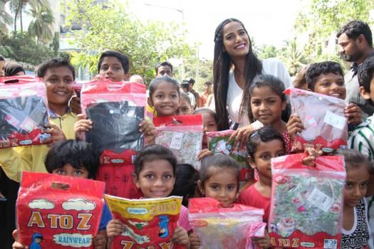 Bollywood actress Poonam Pandey distribute raincoats to street children in Mumbai.