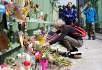 Louise Gray (L) places a bouquet of flowers along a footbridge at the Hollywood Transit Center on June 2, 2017 in Portland, Oregon. The center was the site where last week three men were stabbed, two fatally, after they stood up for two women who were being harassed on a MAX train.