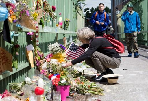 Louise Gray (L) places a bouquet of flowers along a footbridge at the Hollywood Transit Center on June 2, 2017 in Portland, Oregon. The center was the site where last week three men were stabbed, two fatally, after they stood up for two women who were being harassed on a MAX train.
