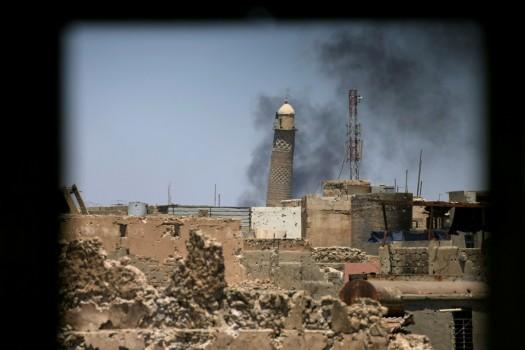 Al-Hadba minaret at the Grand Mosque is seen through a building window in the old city of Mosul, Iraq.