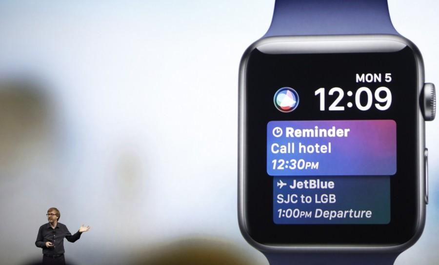 Kevin Lynch, VP of Technology at Apple, speaks near a projection of an Apple Watch. A new Siri interface on the Apple Watch will also blend users' calendar information with other useful details, like airline tickets they may have booked, the company said. While Siri was previously available on the Apple Watch, the assistant's ability to automatically show information was limited. WWDC 2017,WWDC,Apple,iMac,MacBook Pro series,Worldwide Developer Conference,Apple HomePod,Apple iMac