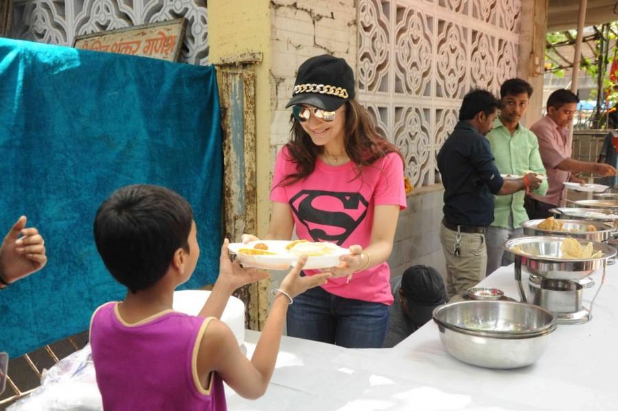 Indian film actress Ameesha Patel distributes food to poor people outside a Temple in Mumbai. Ameesha Patel,actress Ameesha Patel,Ameesha Patel distributes food