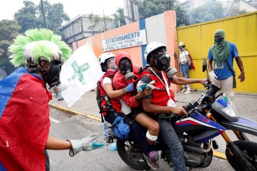 An injured demonstrator is helped by volunteer members of a primary care response team during a rally against Venezuela's President Nicolas Maduro in Caracas, Venezuela.