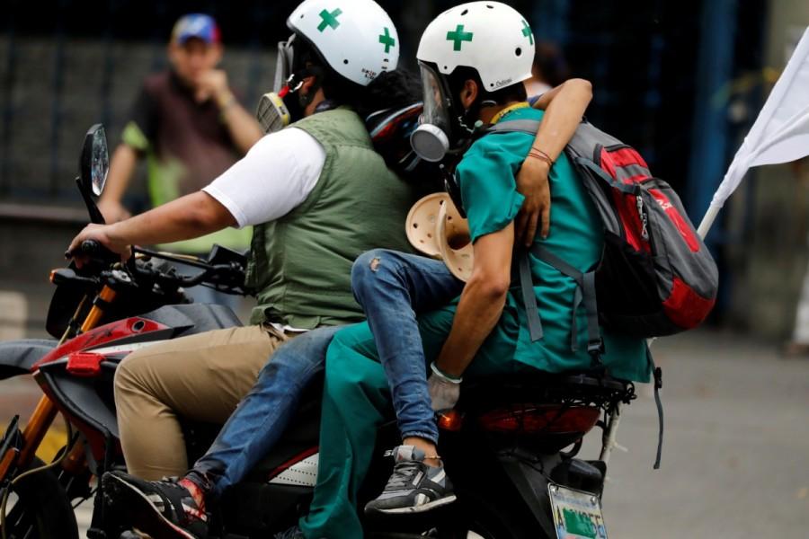 Volunteer members of a primary care response team carry an injured opposition supporter on a motorcycle during a protest against Venezuelan President Nicolas Maduro's government in Caracas, Venezuela. Venezuela,Venezuela protest medics,rubber bullets,tear gas,President Nicolas Maduro