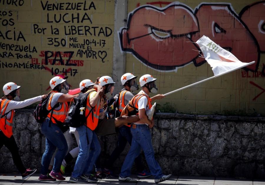 Volunteer members of a primary care response team carry an injured opposition supporter during a protest against Venezuelan President Nicolas Maduro's government in Caracas, Venezuela. Venezuela,Venezuela protest medics,rubber bullets,tear gas,President Nicolas Maduro
