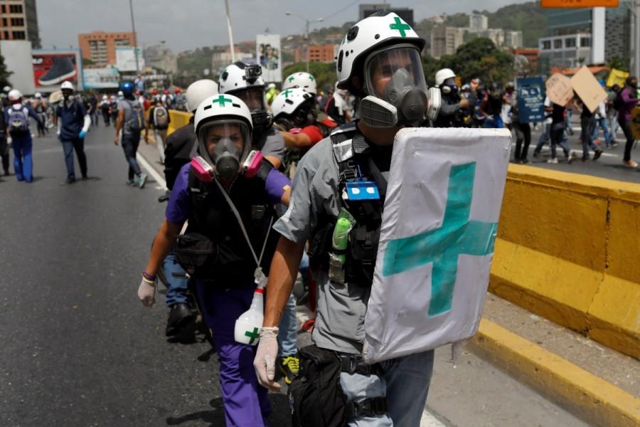 Volunteers, members of a primary care response team, walk together during a rally against Venezuela's President Nicolas Maduro in Caracas, Venezuela. Venezuela,Venezuela protest medics,rubber bullets,tear gas,President Nicolas Maduro