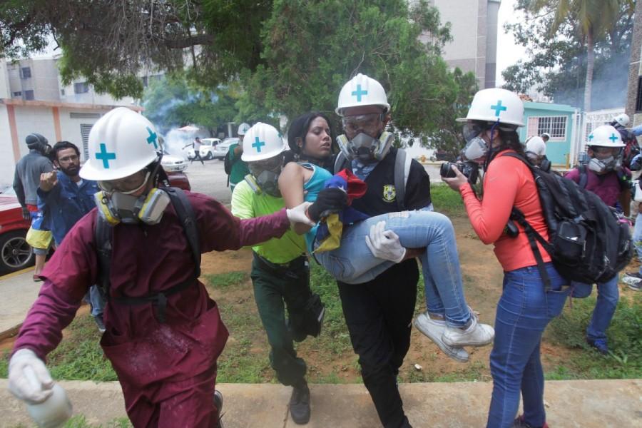 Volunteers, members of a primary care response team, carry an injured opposition supporter during a rally against Venezuelan President Nicolas Maduro in Maracaibo, Venezuela. Venezuela,Venezuela protest medics,rubber bullets,tear gas,President Nicolas Maduro