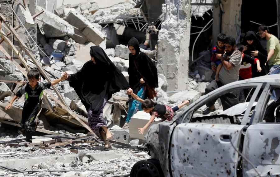 Civilians displaced by fighting between the Iraqi forces and Islamic State militants walk past destroyed houses in Mosul's al-Zanjili's district. Western Mosul,Mosul,Islamic State,Children flee,Islamic State’s last