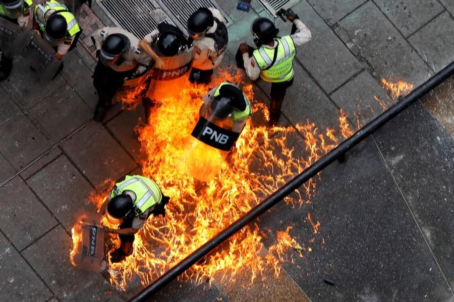 Riot security forces members catch fire during riots at a rally against Venezuelan President Nicolas Maduro's government in Caracas, Venezuela, June 7, 2017. Venezuela,Venezuela capital,Violence engulfs Venezuela,teenage protester dies,Riot security forces