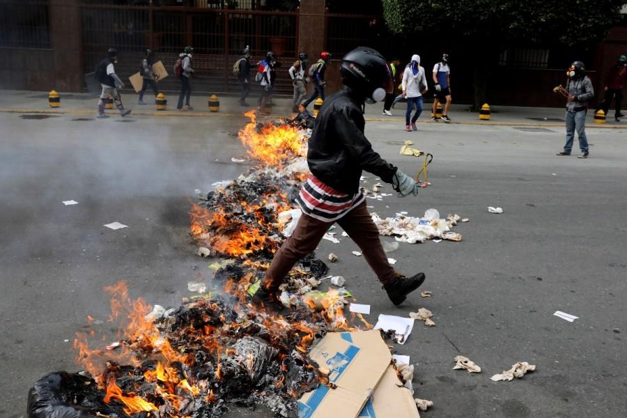 A demonstrator walks past a barricade during riots at a rally against Venezuelan President Nicolas Maduro's government in Caracas, Venezuela, June 7, 2017. Venezuela,Venezuela capital,Violence engulfs Venezuela,teenage protester dies,Riot security forces