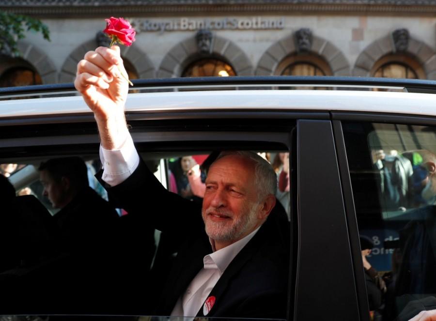 Labour Party leader Jeremy Corbyn holds a red rose after a rally in Glasgow. Britain's Prime Minister,Theresa May,Britain's Prime Minister Theresa May,Britain Prime Minister Theresa May,Labour Party,Jeremy Corbyn,UK campaign trail,UK General election,UK General election 2017