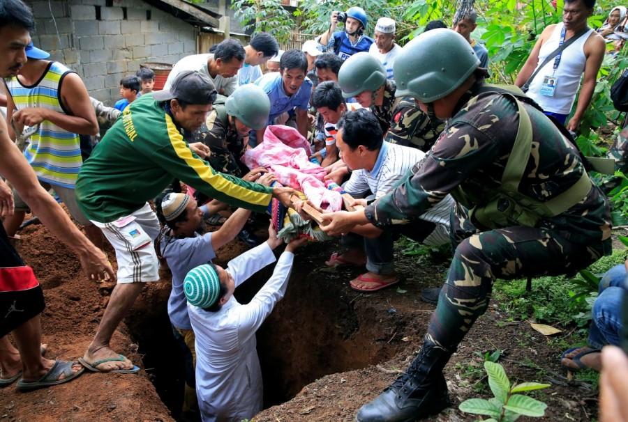 Soldiers and residents carry the body of a Muslim boy who was hit by a stray bullet while praying inside a mosque, as government troops continue their assault against insurgents from the Maute group, who has taken over large parts of the Marawi City. Philippines battles Islamist fighters,Islamist fighters,Marawi City,Islamic State,Syria,Iraq,Philippine island
