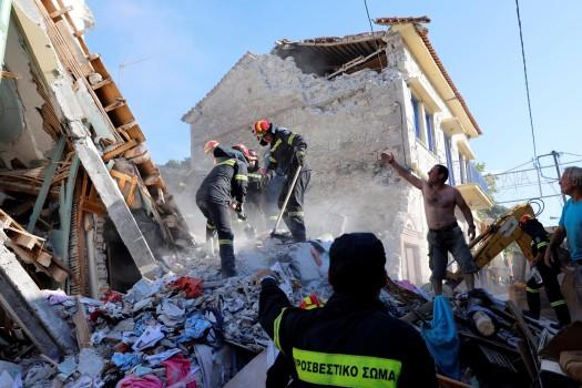 Rescue team members search for victims at a collapsed building in the village of Vrissa on the Greek island of Lesbos, Greece, after a strong earthquake shook the eastern Aegean.
