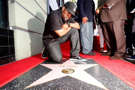 Rapper Ice Cube poses by his star after it was unveiled.