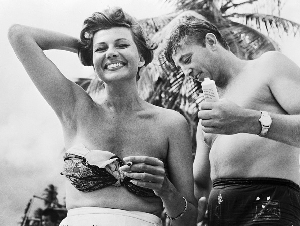 Robert Mitchum applies suntan lotion to Rita Hayworth's back on a beach at Port of Spain, Trinidad, where the two are filming Fire Down Below. Beach Babes,Beach Babes pics,Beach Babes images,Beach Babes stills,Beach Babes pictures,Beach Babes photos,Beach Babes hot pics,Beach Babes hot images,Beach Babes hot stills,Beach Babes hot pictures