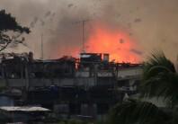 Debris and fire is seen after an OV-10 Bronco aircraft released a bomb, during an airstrike, as government forces continue their assault against insurgents from the Maute group, who have taken over large parts of Marawi City.