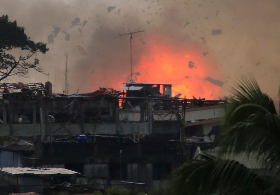 Debris and fire is seen after an OV-10 Bronco aircraft released a bomb, during an airstrike, as government forces continue their assault against insurgents from the Maute group, who have taken over large parts of Marawi City. Philippine city,Philippine aircraft,Philippine troops,Islamist militants,Eid festival