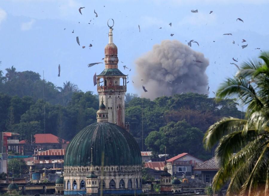 Debris and smoke are seen after an OV-10 Bronco aircraft released a bomb, during an airstrike, as government troops continue their assault against insurgents from the Maute group, who have taken over parts of Marawi city, Philippines. Philippine city,Philippine aircraft,Philippine troops,Islamist militants,Eid festival