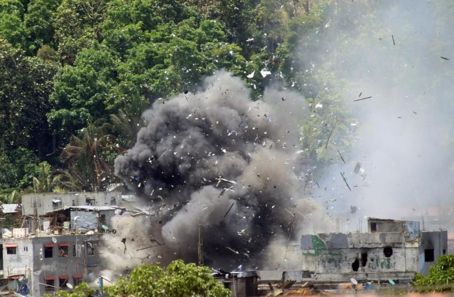Debris and smoke are seen after an OV-10 Bronco aircraft released a bomb during an airstrike, as government forces continue their assault against insurgents from the Maute group, who have taken over large parts of Marawi City. Philippine city,Philippine aircraft,Philippine troops,Islamist militants,Eid festival