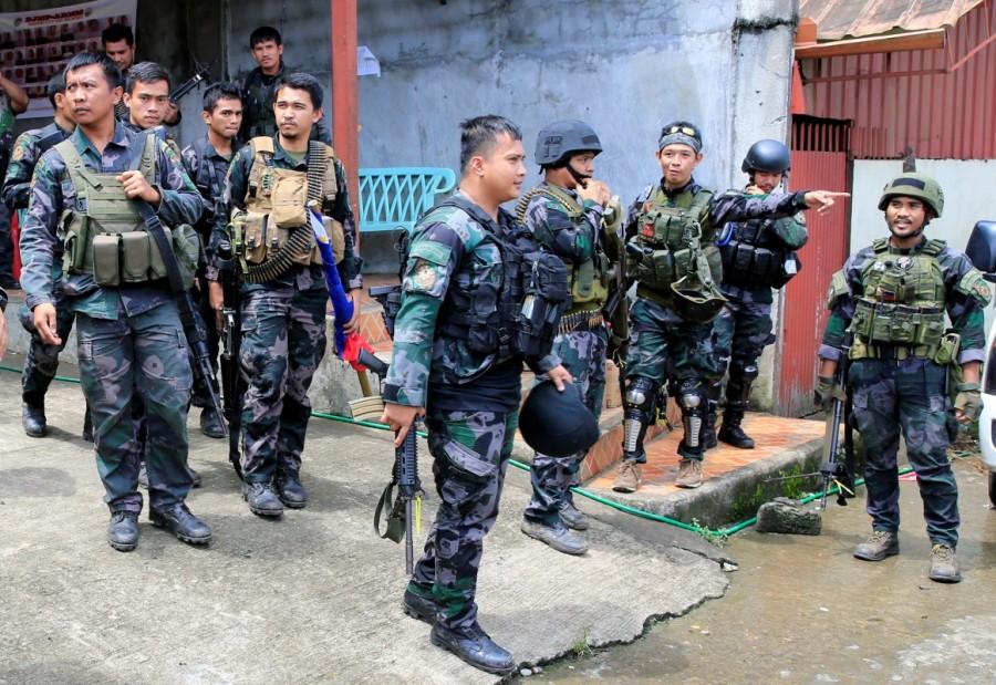Members of the Philippine National Police Special Action Force prepare to board a PNP vehicle as reinforcements, as government forces continue their assault against insurgents from the Maute group, who have taken over large parts of Marawi City. Philippine city,Philippine aircraft,Philippine troops,Islamist militants,Eid festival