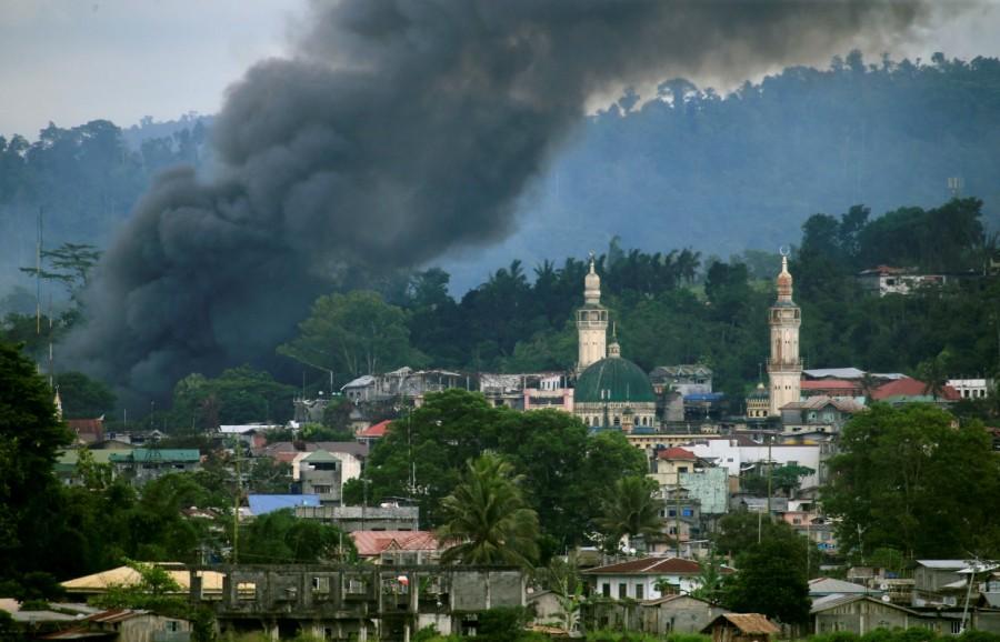 Smoke billows from a burning building as government troops continue their assault against insurgents from the Maute group, who have taken over large parts of Marawi city. Philippine city,Philippine aircraft,Philippine troops,Islamist militants,Eid festival