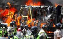 Riot security forces members congregate next to a government truck that was set on fire during a rally against Venezuelan President Nicolas Maduro's government in Caracas, Venezuela June 22, 2017.