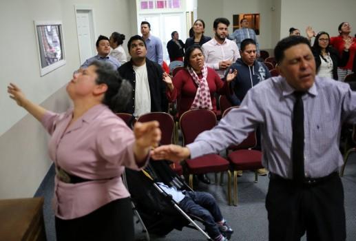 Honduran migrants Raul Contreras, his mother Daysi Alas (C) and step-father Ananin Cruz attend a church service held in Spanish in Toronto. Thousands of people who fled to Canada to escape President Donald Trump’s crackdown on illegal migrants have become trapped in legal limbo because of an overburdened refugee system, struggling to find work, permanent housing or enroll their children in schools.