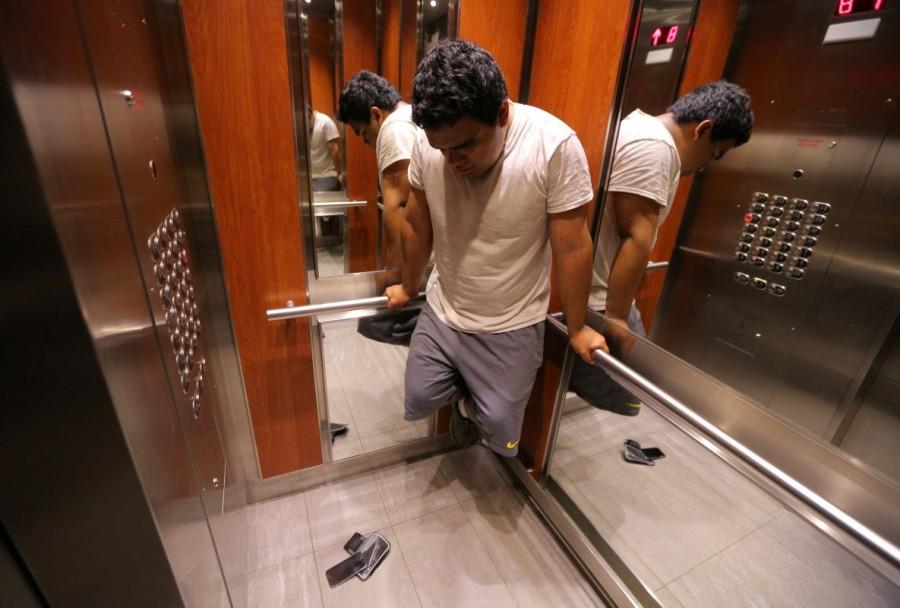 Raul Contreras balances on the bars of an elevator at a long-stay hotel in Toronto. Refugee claims are taking longer to be completed than at any time in the past five years, according to previously unpublished Immigration and Refugee Board data provided to Reuters. Asylum seekers stuck,Canadian legal limbo,President Donald Trump,Donald Trump,illegal migrants,refugee