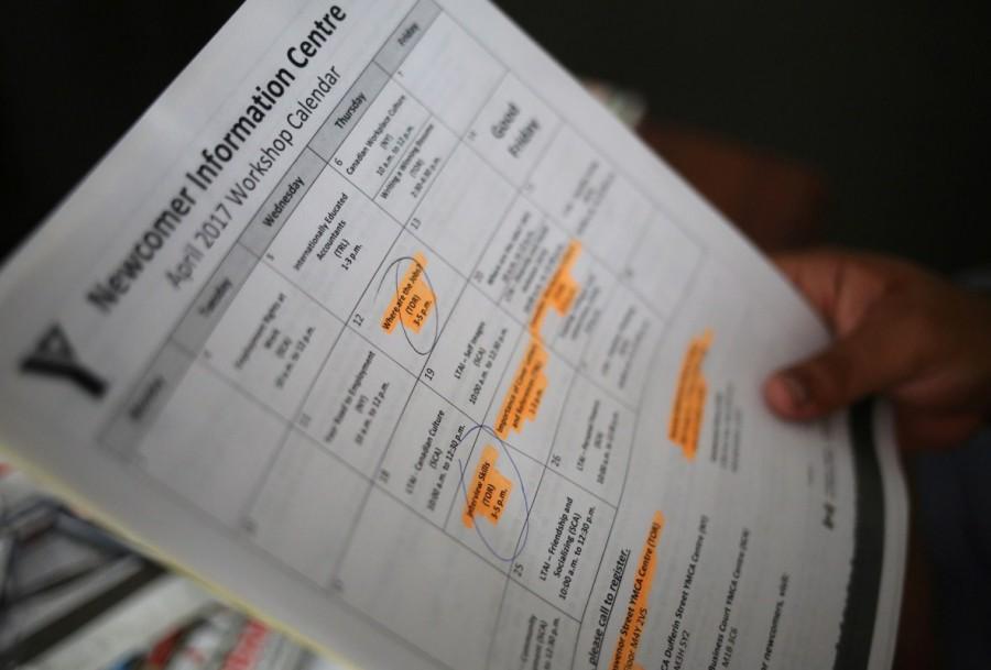 Raul Contreras looks at job-seeking materials provided by the YMCA. Raul went to high school in North Carolina but needs to improve his grades in order to attend college. He has been told to contact the school system in early August again before they start the school year in order to take an assessment exam. Asylum seekers stuck,Canadian legal limbo,President Donald Trump,Donald Trump,illegal migrants,refugee