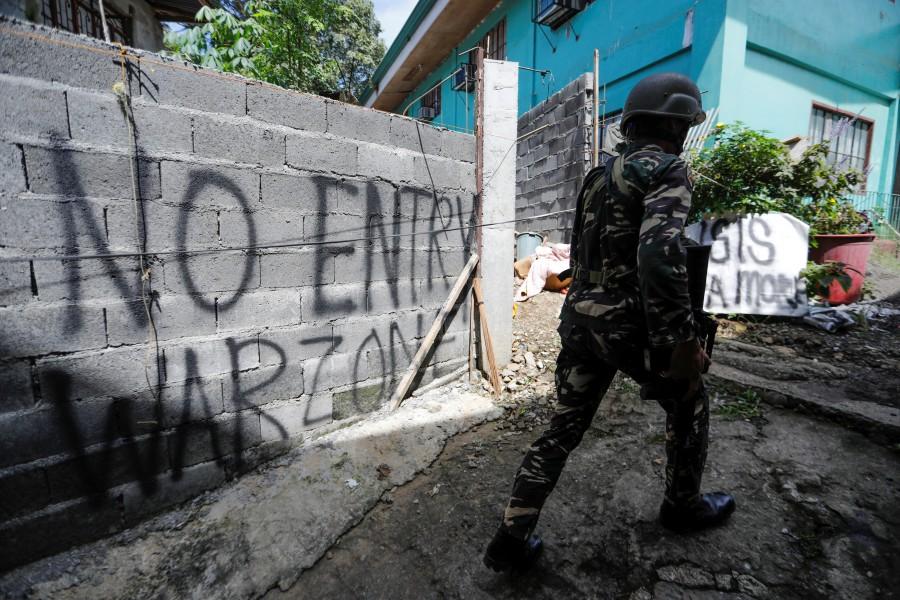 A Filipino soldier walks as government troops continue their assault. Philippine city,Battle of Philippine city,Marawi City,fight rebels,Islamic State