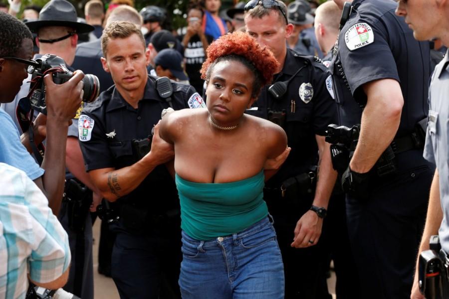 Police detain a counter-protester during the aftermath of a rally by members of the Ku Klux Klan in support of Confederate monuments in Charlottesville. Ku Klux Klan,Ku Klux Klan rally,Ku Klux Klan rally in Virginia,Confederate monuments