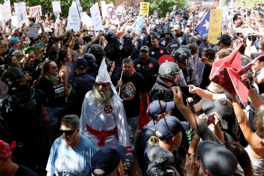 Riot police protect members of the Ku Klux Klan from counter-protesters as they arrive to rally in opposition to city proposals to remove or make changes to Confederate monuments in Charlottesville, Virginia. Ku Klux Klan,Ku Klux Klan rally,Ku Klux Klan rally in Virginia,Confederate monuments