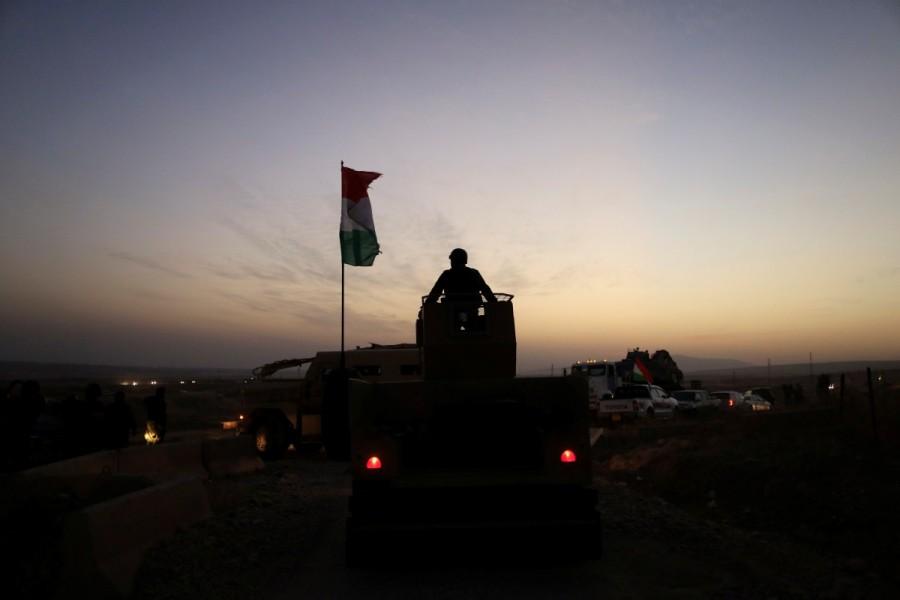 A Kurdish Peshmerga fighter looks over as he stands on the top of a humvee in front of an Islamic State militants' position outside the town of Naweran near Mosul. Battle for Mosul,Mosul,Islamic State in Mosul,Isis Mosul,Mosul Battle,Islamic State