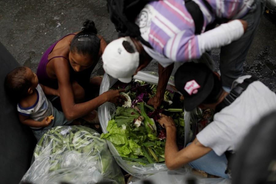 People search for food in garbage bags next to a supermarket in Caracas. Many Venezuelans were stocking up on food in anticipation of closed shops and trouble, worsening already extremely long lines at supermarkets and ATMS. Venezuela,Stocking up before Venezuela,Venezuela strike