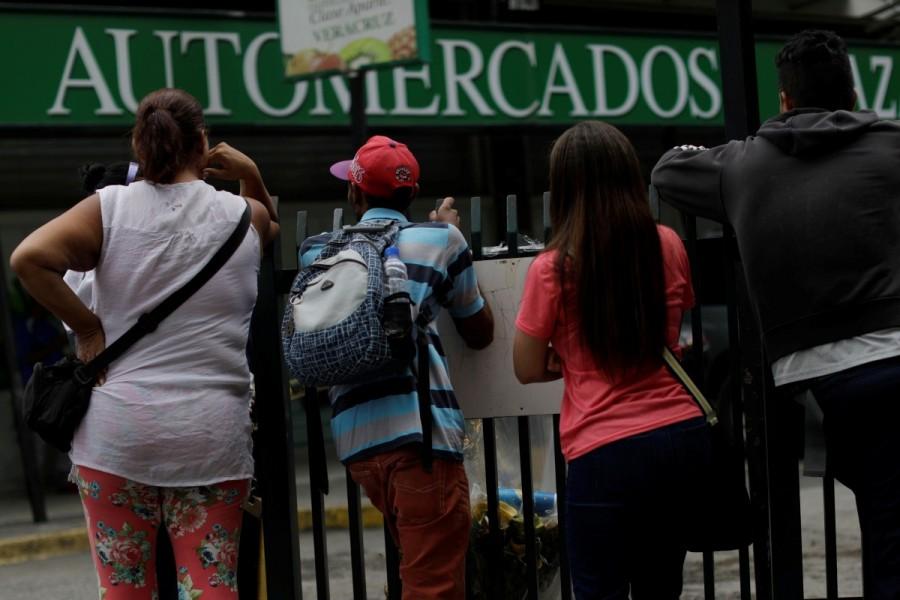 People gather to buy food and other staple goods outside a supermarket in Caracas. Venezuela,Stocking up before Venezuela,Venezuela strike
