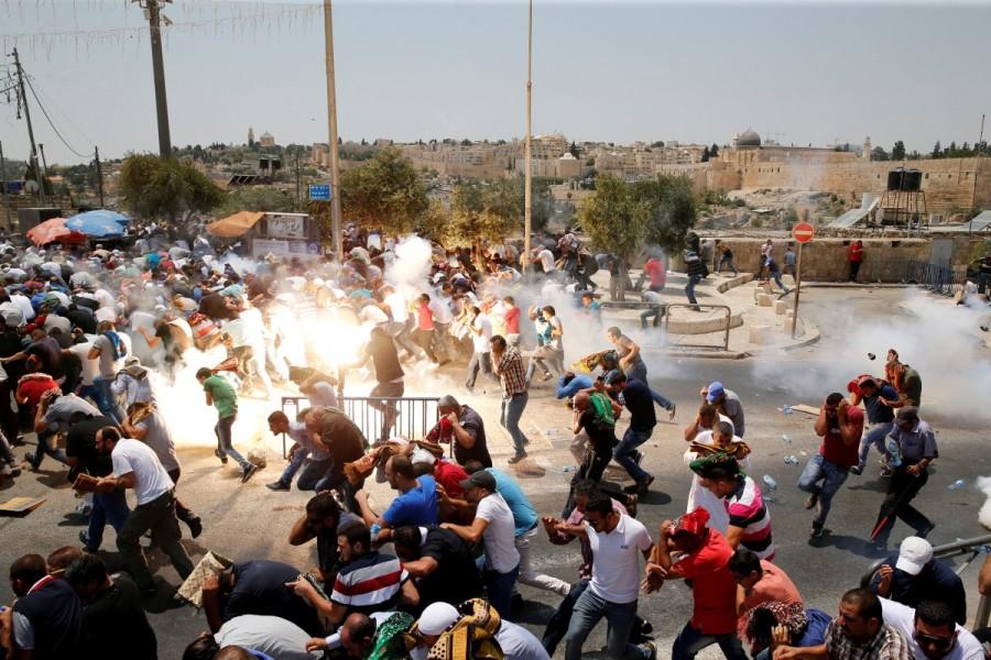 Palestinians react following tear gas that was shot by Israeli forces after Friday prayers on a street outside Jerusalem's Old city during a "Day of Rage" to protest at new Israeli security measures at Jerusalem's holiest site. Jerusalem metal detectors,Jerusalem,Jerusalem detectors,Aqsa mosque,Jerusalem Old City,Israel removes Jerusalem metal detectors,Israel