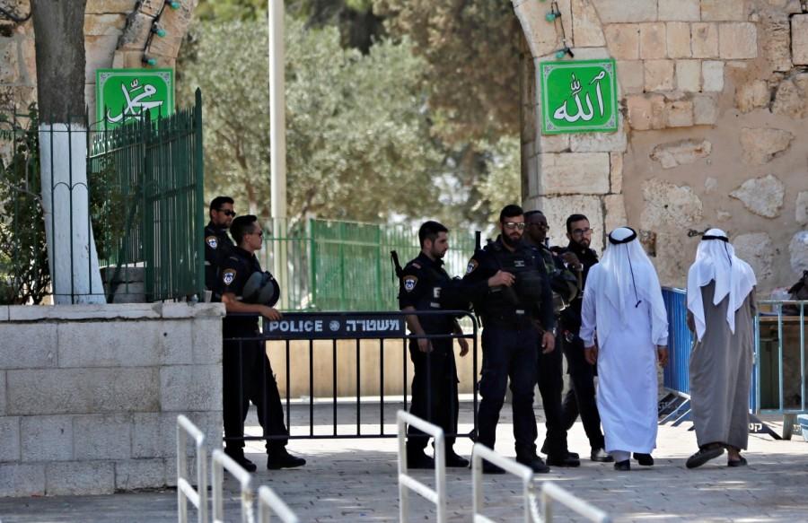 Palestinians walk next to Israeli security forces at the entrance of the compound the morning after Israel removed the new security measures. Jerusalem metal detectors,Jerusalem,Jerusalem detectors,Aqsa mosque,Jerusalem Old City,Israel removes Jerusalem metal detectors,Israel