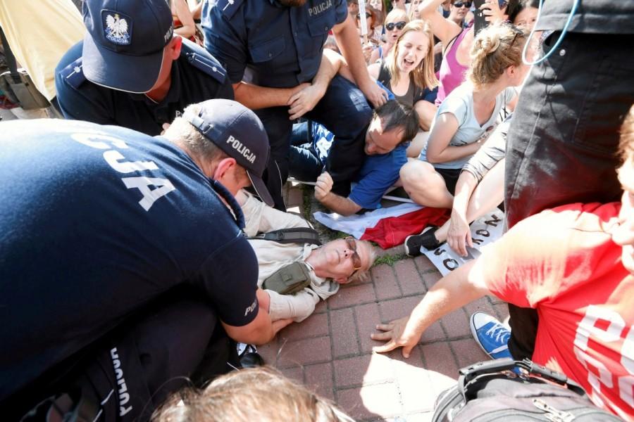 Police officers detain people during a protest next to the Law and Justice party headquarters in Warsaw, Poland, July 24, 2017. Polish court,Thousands protest Polish court,Supreme Court judges,European Union
