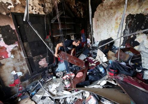 An Afghan shopkeeper inspects his shop after a suicide attack in Kabul, Afghanistan.