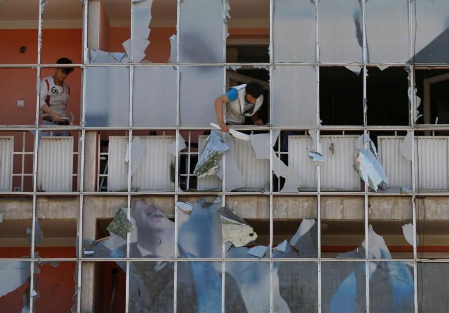 An Afghan man removes fragments of glass from a building after a suicide attack in Kabul, Afghanistan. Taliban car bomb attack,car bomb attack,Kabul,Kabul car bomb attack,Kabul car bomb attack in Taliban,Taliban suicide attacker