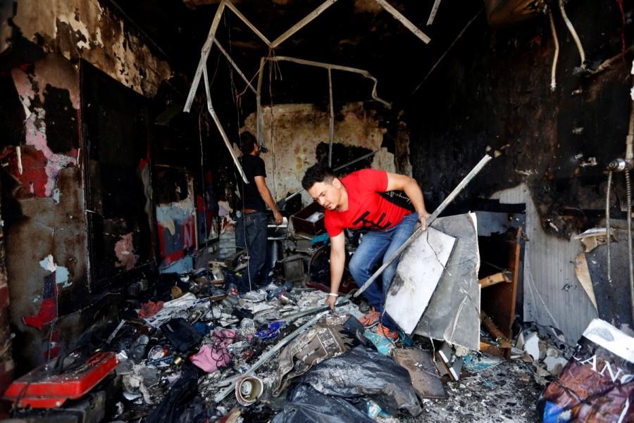 An Afghan shopkeeper inspects his shop after a suicide attack in Kabul, Afghanistan. Taliban car bomb attack,car bomb attack,Kabul,Kabul car bomb attack,Kabul car bomb attack in Taliban,Taliban suicide attacker