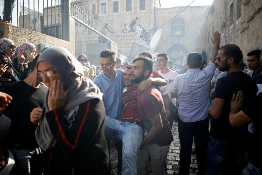 Palestinians carry an injured man in a street at Jerusalem's Old city outside the compound known to Muslims as Noble Sanctuary and to Jews as Temple Mount. Jerusalem holy site,Jerusalem holy,Muslim worshippers,Jerusalem's Al-Aqsa Mosque,Israel