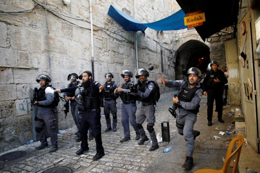 An Israeli policeman throws a stun grenade in a street at Jerusalem's Old city outside the compound known to Muslims as Noble Sanctuary and to Jews as Temple Mount. Jerusalem holy site,Jerusalem holy,Muslim worshippers,Jerusalem's Al-Aqsa Mosque,Israel
