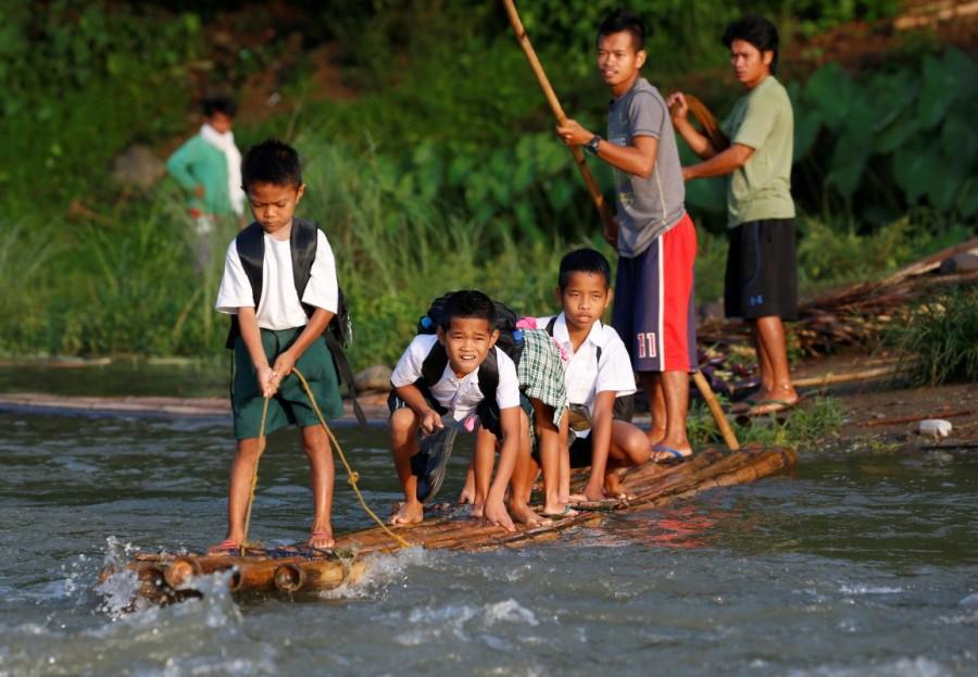 Schoolchildren ride on a makeshift raft to attend the opening of classes at a remote Casili Elementary School in Montalban, Rizal northeast of Manila, Philippines. Long journey to school,journey to school